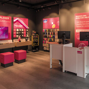 Telekom Shop Innenansicht mit Magenta-Wänden, Handys und Beratungstresen
